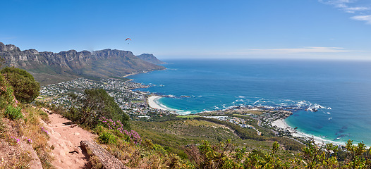 Image showing Scenic hiking trail along Table Mountain with beautiful views of a coastal city against a blue sky background. Magnificent panoramic of peaceful and rugged landscape at the sea to explore and travel