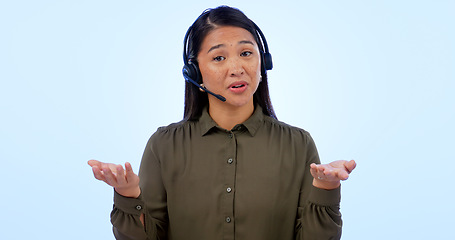 Image showing Portrait, customer service and support with an asian woman consulting in studio on a blue background. Contact us, crm or telemarketing with a young call center employee talking on a headset for help