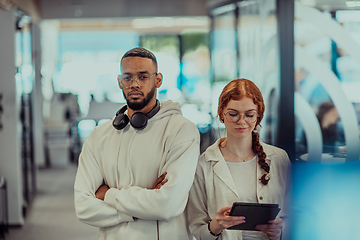 Image showing In a modern office African American young businessman and his businesswoman colleague, with her striking orange hair, engage in collaborative problem-solving sessions