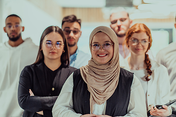 Image showing A group of young business professionals stands together, taking a well-deserved break from their busy workday, showcasing camaraderie, teamwork, and a moment of relaxation in their dynamic workplace