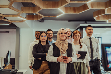 Image showing A group of young business professionals stands together, taking a well-deserved break from their busy workday, showcasing camaraderie, teamwork, and a moment of relaxation in their dynamic workplace