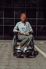 Image showing In front of a modern corporate building, a young woman sitting in a wheelchair confidently, symbolizing empowerment, inclusivity, and the strength to overcome challenges in the business world