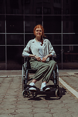 Image showing In front of a modern corporate building, a young woman sitting in a wheelchair confidently, symbolizing empowerment, inclusivity, and the strength to overcome challenges in the business world