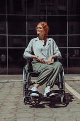 Image showing In front of a modern corporate building, a young woman sitting in a wheelchair confidently, symbolizing empowerment, inclusivity, and the strength to overcome challenges in the business world