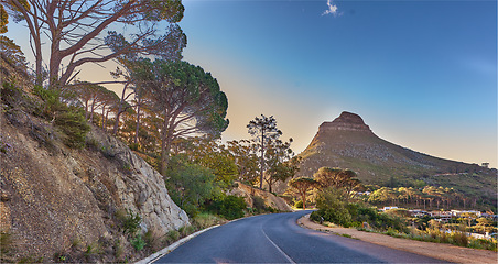 Image showing An empty road on the mountain at sunrise. Street overlooking mountain peak with a scenic view of the city from a street on the mountain at sunset. The landscape of a beautiful view of Lions head