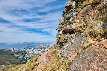 Image showing Copyspace landscape view of mountain trails on Lions Head, Table Mountain National Park in Cape Town, South Africa. Natural landmark for hiking and fitness walks against a cloudy blue sky in summer