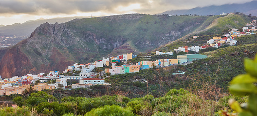 Image showing Colorful buildings in Santa Cruz, La Palma, Canary Islands with copy space. Beautiful cityscape with bright colors and mountains. A vibrant holiday, vacation and getaway destination on the hillside