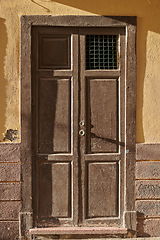 Image showing Weathered and damaged architectural structure with rustic, aged pattern and frame on an entrance or doorway in Spain. An old wooden vintage door of an ancient building in Santa Cruz de La Palma.