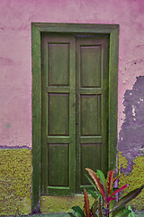 Image showing Vintage, aged structure with architectural details on moss covered walls in an urban town in Spain. A door at an entrance of an old fashioned rustic building in Santa Cruz, de La Palma.