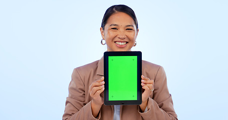 Image showing Portrait, tablet and green screen space with an asian woman in studio on a blue background for website promotion. Tech, mockup or chromakey and a person holding a display with tracking markers