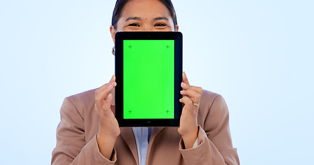 Image showing Portrait, tablet and green screen mockup with an asian woman in studio on a blue background for website promotion. Tech, space or chromakey and a person holding a display with tracking markers