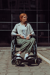 Image showing In front of a modern corporate building, a young woman sitting in a wheelchair confidently, symbolizing empowerment, inclusivity, and the strength to overcome challenges in the business world