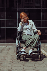 Image showing In front of a modern corporate building, a young woman sitting in a wheelchair confidently, symbolizing empowerment, inclusivity, and the strength to overcome challenges in the business world