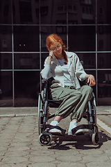 Image showing In front of a modern corporate building, a young woman sitting in a wheelchair confidently, symbolizing empowerment, inclusivity, and the strength to overcome challenges in the business world