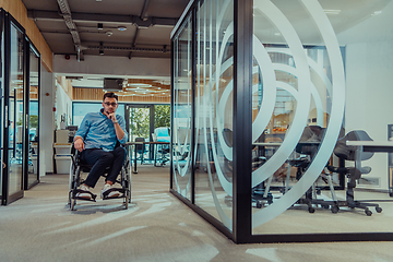 Image showing In a large modern corporation, a determined businessman in a wheelchair navigates through a hallway, embodying empowerment and inclusivity in the corporate world.