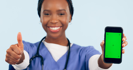 Image showing Green screen, thumbs up and portrait of doctor with phone for telehealth, wellness app and medical news. Healthcare, clinic mockup and black woman with smartphone and emoji sign for website in studio
