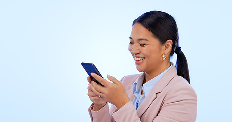 Image showing Business, woman and phone in studio for search, networking and planning with happy expression on blue background. Person, smartphone or technology for scrolling on social media or website on mock up