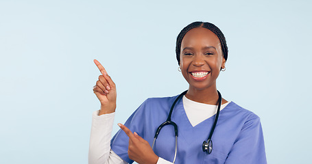 Image showing Black woman, nurse and pointing at medical information, list or announcement with smile in portrait on blue background. Healthcare news, advertising and mockup for health alert and about us in studio