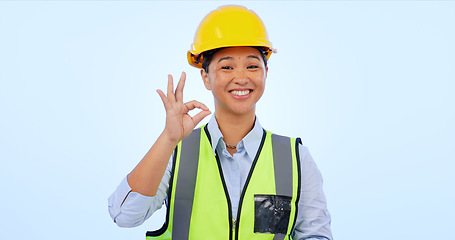 Image showing Woman, okay and hands in smile by engineer for construction by architect in studio by blue background. Asian female, development or success for real estate, inspection and yes sign or emoji in mockup