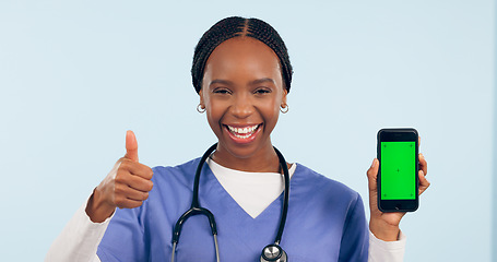 Image showing Green screen, thumbs up and portrait of doctor with phone for telehealth, wellness app or medical news. Healthcare, mockup or black woman with hand sign on smartphone for website in studio background