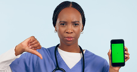 Image showing Phone green screen, portrait and nurse thumbs down in studio isolated on blue background. Smartphone, face and African medical professional with dislike hand sign, health mockup and tracking markers