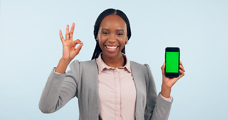 Image showing Business woman, ok sign and green screen phone with portrait for review, choice or app by blue background. African entrepreneur, yes and studio for smartphone mockup, chromakey or tracking markers