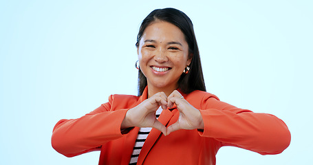 Image showing Smile, portrait and a woman with heart hands on a blue background for love, support or care. Happy, corporate and a female employee with a gesture to show romance, trust or hope on a studio backdrop