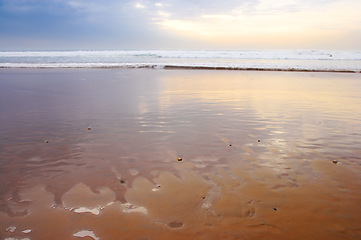 Image showing Seascape and landscape of a golden sunset on the west coast of Jutland in Loekken, Denmark. Beautiful cloudscape on an empty beach at dusk. Clouds over the ocean and sea in the evening with copyspace