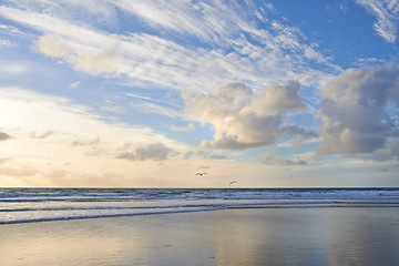 Image showing Seascape and landscape of a golden sunset on the west coast of Jutland in Loekken, Denmark. Beautiful cloudscape on an empty beach at dusk. Clouds over the ocean and sea in the morning