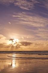 Image showing Seascape of a beautiful sunset on the west coast of Jutland in Loekken, Denmark. Sun setting on the horizon on an empty beach at dusk over the ocean and sea at night with copyspace