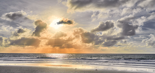 Image showing Seascape and landscape of a golden sunset on the west coast of Jutland in Loekken, Denmark. Beautiful cloudscape on an empty beach at dusk. Clouds over the ocean and sea in the morning with copyspace