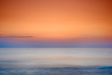 Image showing Copyspace seascape of an orange sunset on the west coast of Jutland in Loekken, Denmark. Sun setting on the horizon on an empty beach at dusk over the ocean and sea at night. Sunrise in the morning