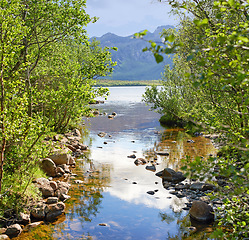 Image showing Landscape of lake and river north of polar and arctic circle in Norland. Mountains and hills in remote area with rocky stream in Bodo, Norway. Traveling abroad and overseas for holiday and vacation