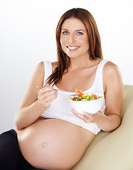 Image showing Portrait, salad and pregnant with woman, vitamins and smile on a white studio background. Person, bowl and model with happiness, girl or pregnancy with vegetables, relax or maternal with healthy meal