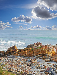 Image showing A rocky coastline in the Western Cape, South Africa on a hot summer day. Clear sky and beaches, a perfect getaway filled with self care resorts and wellness outdoor activities with tropical weather