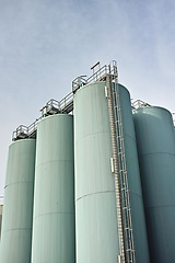 Image showing Silo storage tankers against a gray sky in Danish oil industry. large oil plant storage tanks for export in industrial area. Silo tankers for keeping bulk food products, substances and materials safe