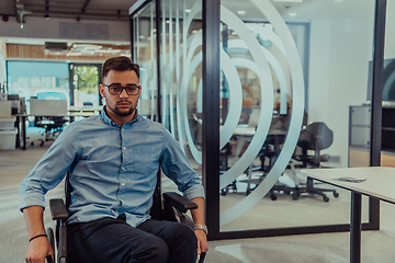 Image showing In a large modern corporation, a determined businessman in a wheelchair navigates through a hallway, embodying empowerment and inclusivity in the corporate world.