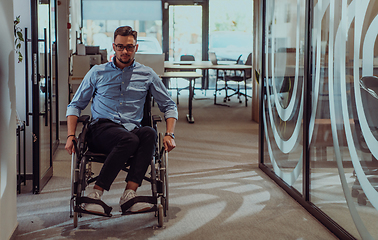 Image showing In a large modern corporation, a determined businessman in a wheelchair navigates through a hallway, embodying empowerment and inclusivity in the corporate world.