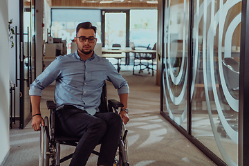 Image showing In a large modern corporation, a determined businessman in a wheelchair navigates through a hallway, embodying empowerment and inclusivity in the corporate world.