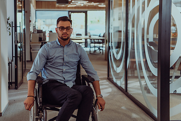 Image showing In a large modern corporation, a determined businessman in a wheelchair navigates through a hallway, embodying empowerment and inclusivity in the corporate world.