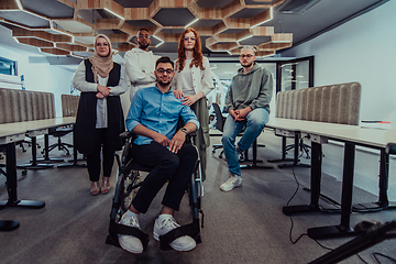 Image showing Young businessmen in a modern office extend a handshake to their business colleague in a wheelchair, showcasing inclusivity, support, and unity in the corporate environment.