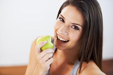 Image showing Woman, smile and eating an apple, health and wellness in portrait, nutrition and vitamins for vegan. Female person, fruit and organic or natural, breakfast and diet in outdoors, fresh and digestion