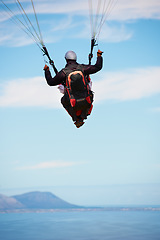 Image showing People, paragliding and freedom in sky, ocean and extreme sport with back for fitness. Coach, partnership and person with adventure, helmet and fearless with backpack, parachute and sea with safety