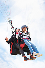 Image showing People, paragliding and happy in sky, together or extreme sport with freedom for fitness. Coach, partnership and person on adventure, helmet or fearless with backpack, parachute or flight with clouds