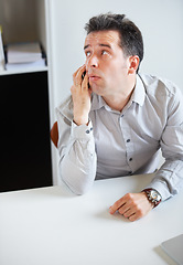 Image showing Phone call, thinking or waiting with a business man sitting at his desk in the office for work. Time, contact and communication with an impatient young employee talking on his mobile in the workplace