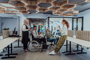 Image showing Young group of business people brainstorming together in a startup space, discussing business projects, investments, and solving challenges.