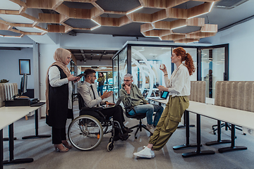 Image showing Young group of business people brainstorming together in a startup space, discussing business projects, investments, and solving challenges.