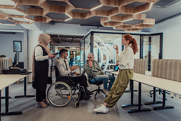 Image showing Young group of business people brainstorming together in a startup space, discussing business projects, investments, and solving challenges.