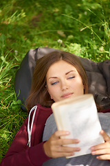 Image showing Happy woman in park with book to relax at university, story or studying for school project. Above, reading and college student on grass in campus garden for research, storytelling and peace on lawn.