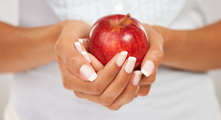 Image showing Hands, apple or fruit with a person closeup for health, diet or nutrition in the kitchen of her home. Food, nutritionist and hunger with an adult eating fresh produce for a healthy weight loss snack